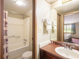 Un baño con bañera, inodoro y lavamanos.