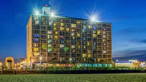 A multi-story hotel with a modern architectural design, featuring numerous windows and balconies. - Boardwalk Resort and Villas (Virginia Beach)