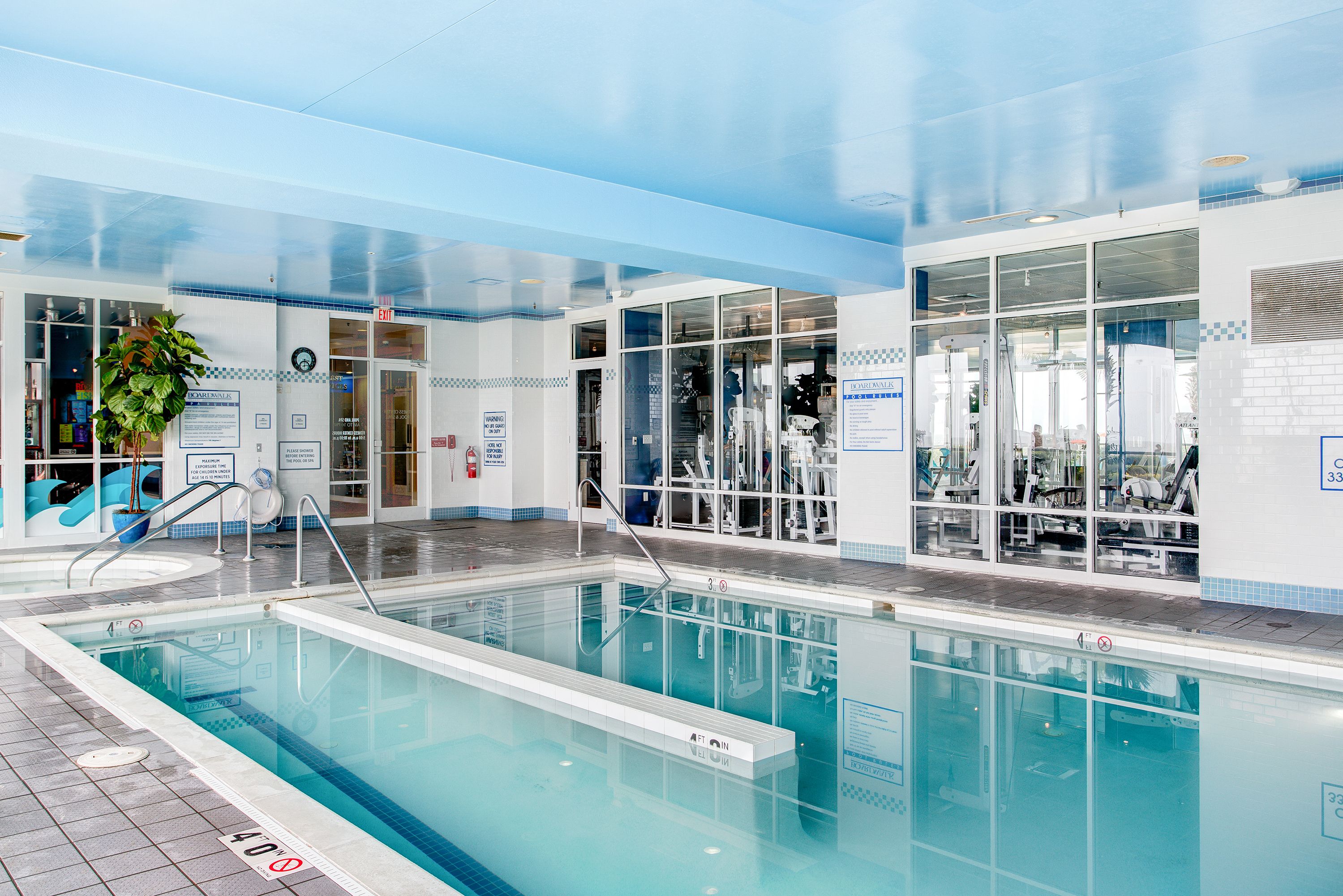 An indoor swimming pool with clear water, a lifeguard chair, and a sign indicating a 40-meter depth.