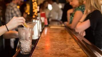 A bar setting with a person preparing a drink.