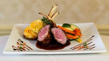 A plated dish with meat, vegetables, and a sauce.