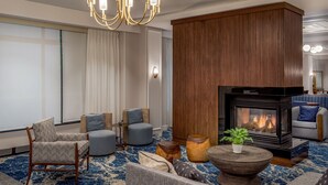 Un salon moderne doté d’une cheminée, de sièges confortables et d’un lustre.