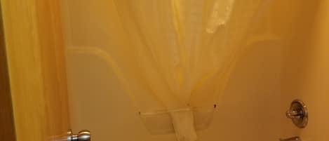 Ein Badezimmer mit einer Badewanne, einer Duschvorhang und einem Handtuch, das an der Wand hängt.