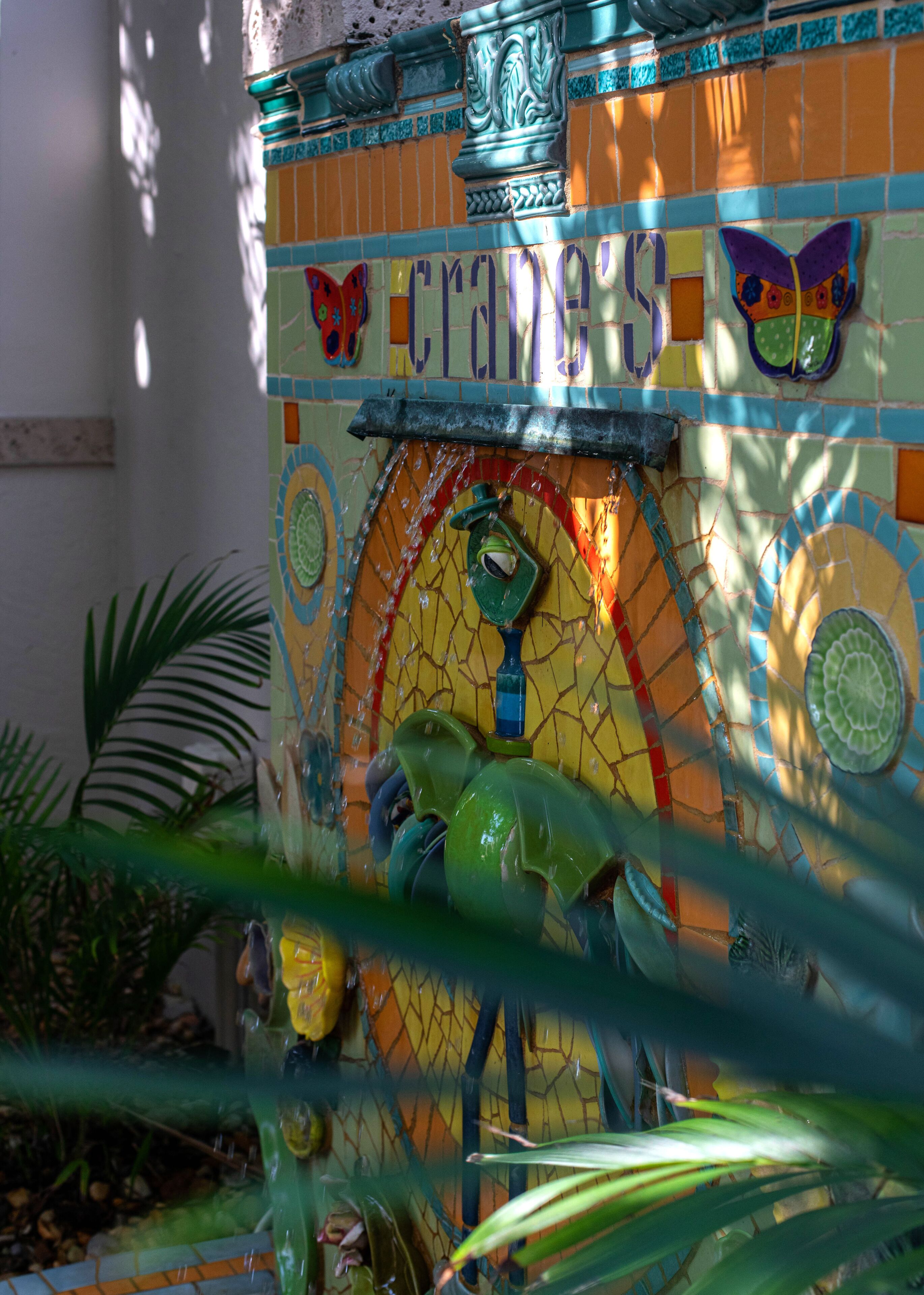 A colorful mosaic wall with the word "FRAGILE" and a butterfly design.