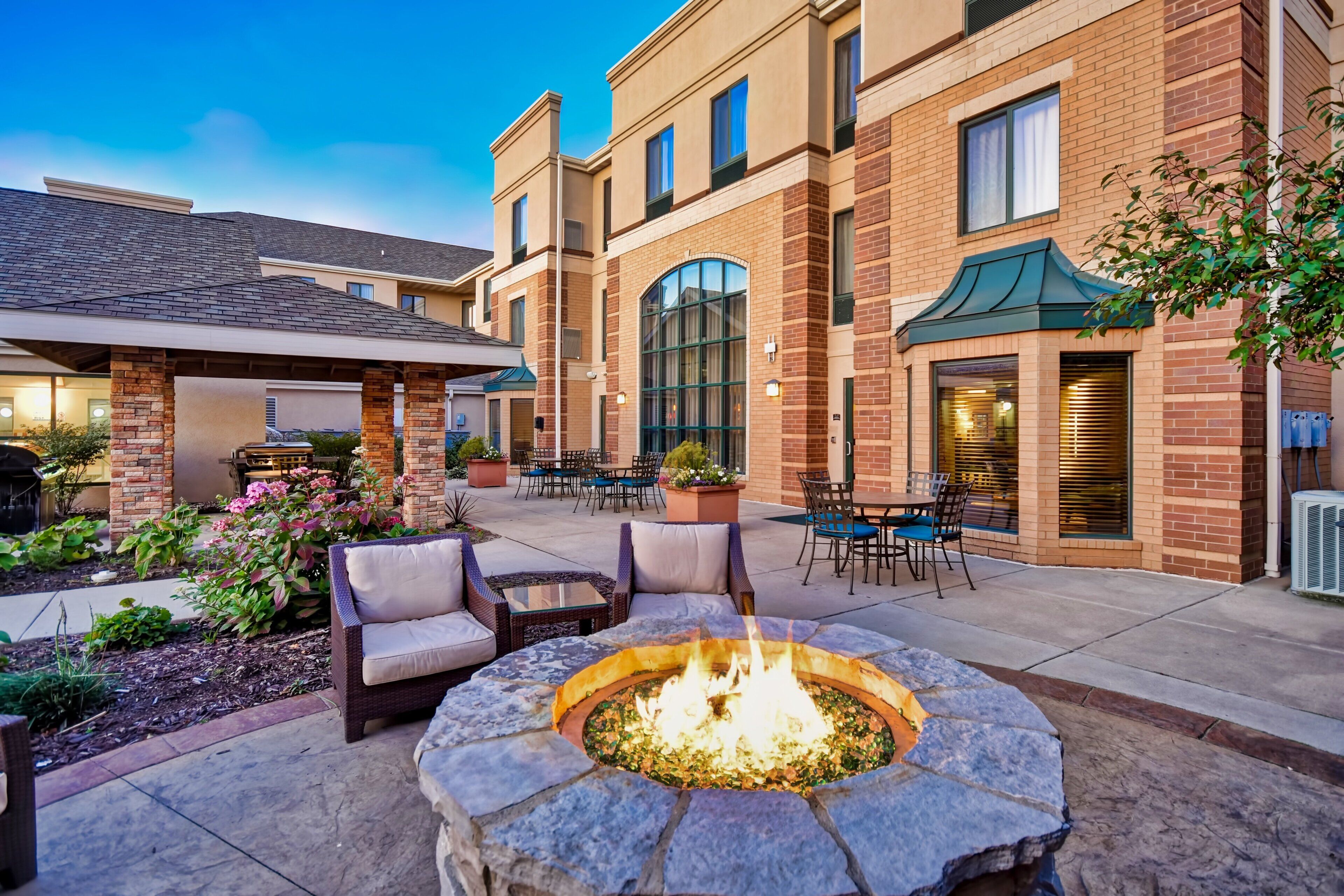 Un patio con mobiliario exterior, una chimenea y un porche cubierto.