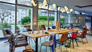 A modern dining area with a large table, chairs, and a view of the outside.