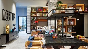 A modern living room with a black coffee table, multiple seating options, and a bookshelf filled with books and decorative items.