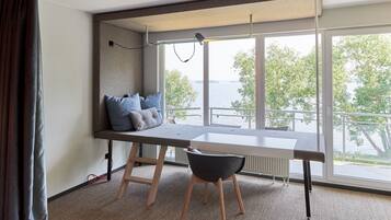A modern room with a large window, a desk, and a chair.