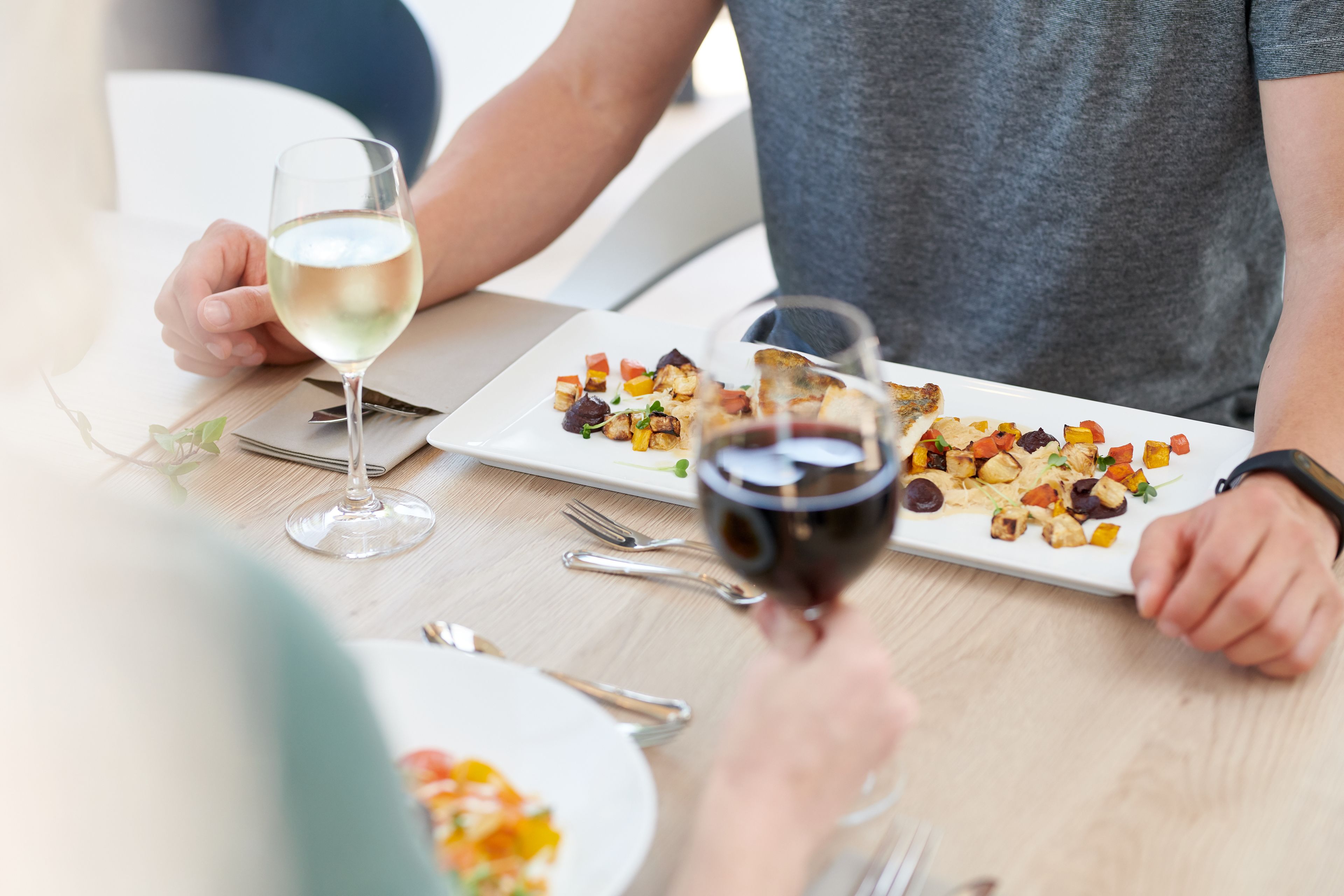 Een eettafel met twee borden eten en twee wijnglazen.