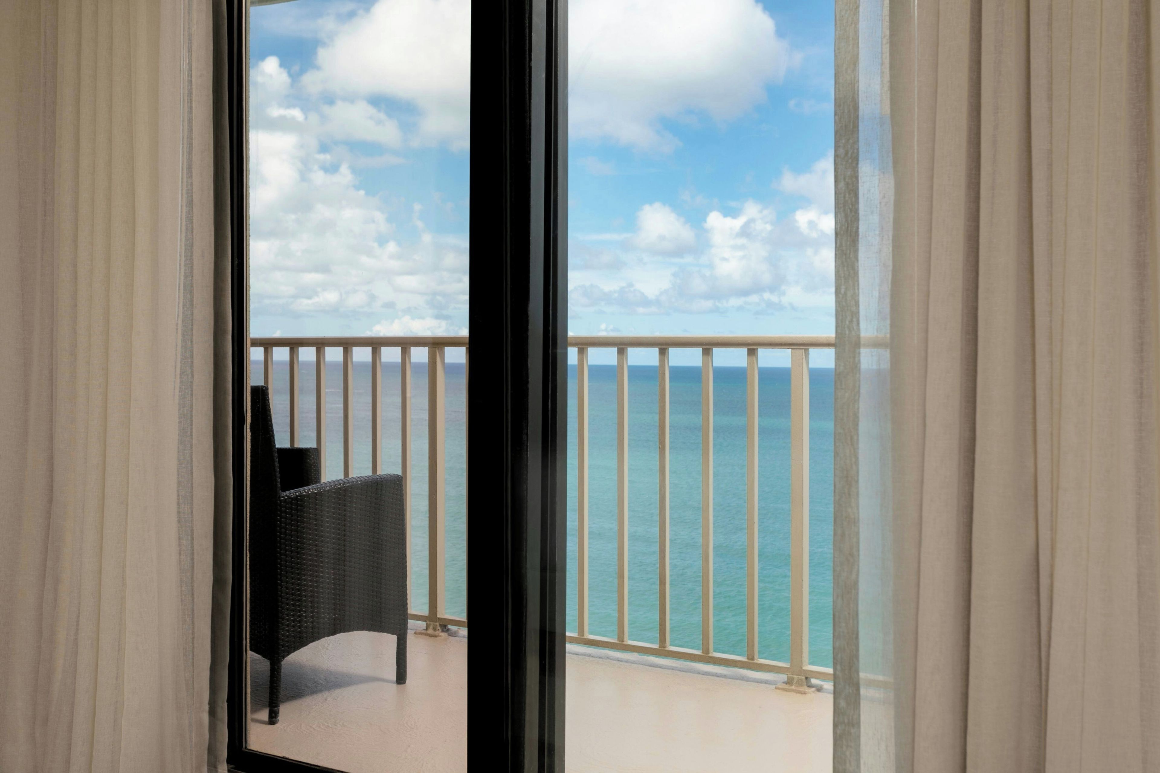 A balcony with a view of the sea and sky.