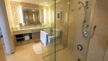 A modern bathroom with a glass-enclosed shower, a vanity with a mirror, and a toilet.