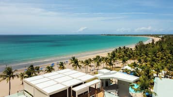 Un complexe hôtelier doté d’une piscine, d’une plage et de palmiers.