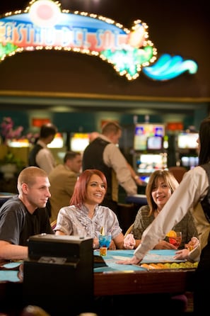 A casino with a blackjack table and people playing.