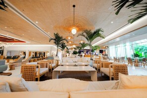 A spacious lounge area with multiple seating options, including sofas and chairs, and a central coffee table.