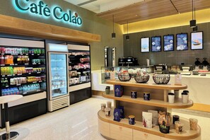 A café with a refrigerated display of beverages, a coffee bar, and a menu board. - Marriott Isla Verde Beach Resort (Carolina)
