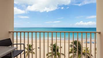 A balcony with a view of a beach and ocean.