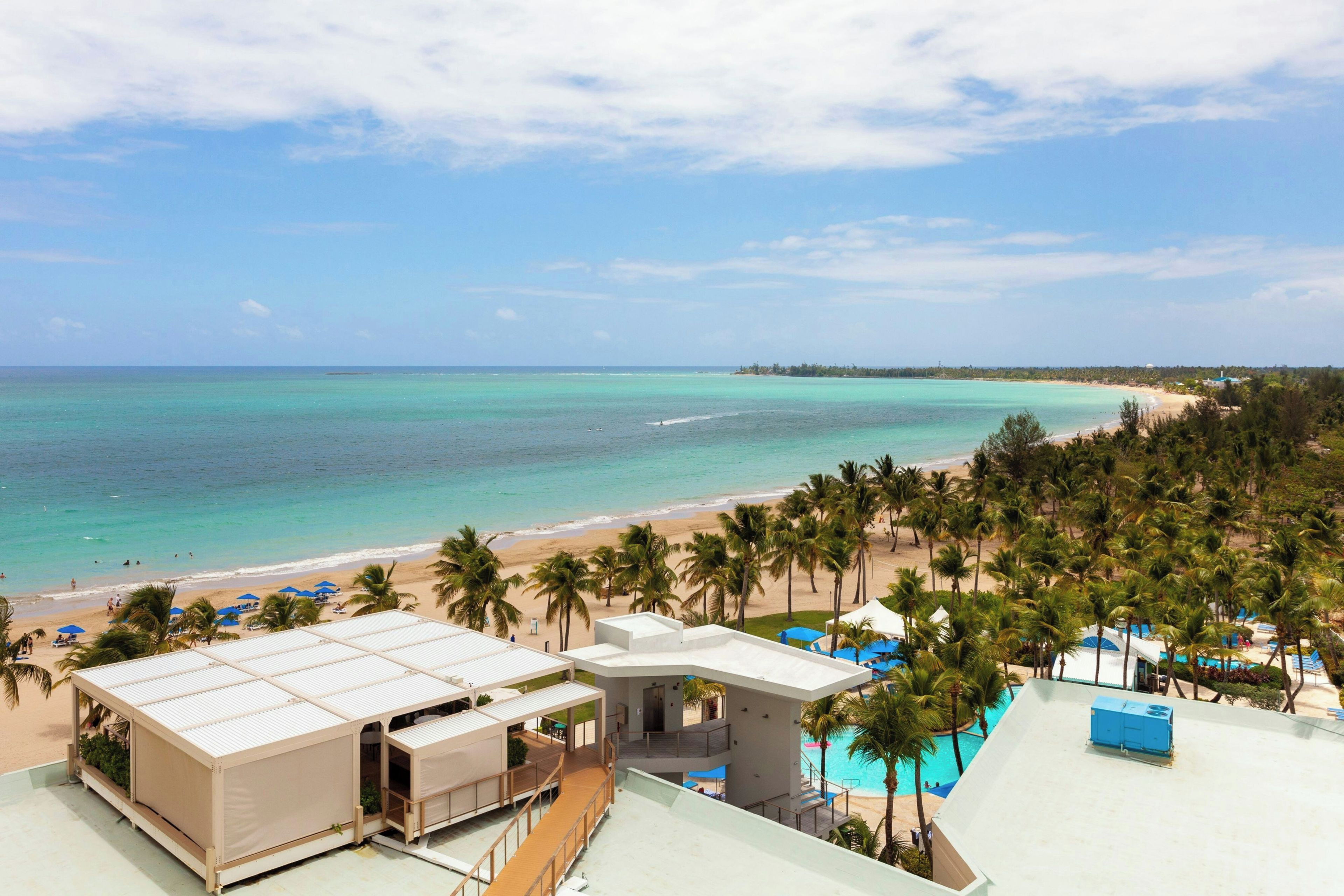 Resort com vista para a praia, incluindo área de piscina e vários níveis de acomodação.