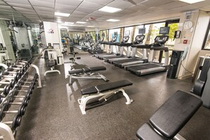 A gym with treadmills, dumbbells, and weight machines.