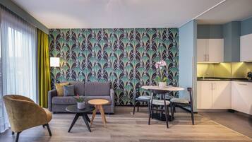 Una sala moderna con sofá, sillón y mesa de comedor.