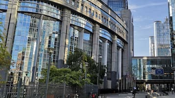 A modern building with curved architecture, large windows, and a pedestrian walkway.