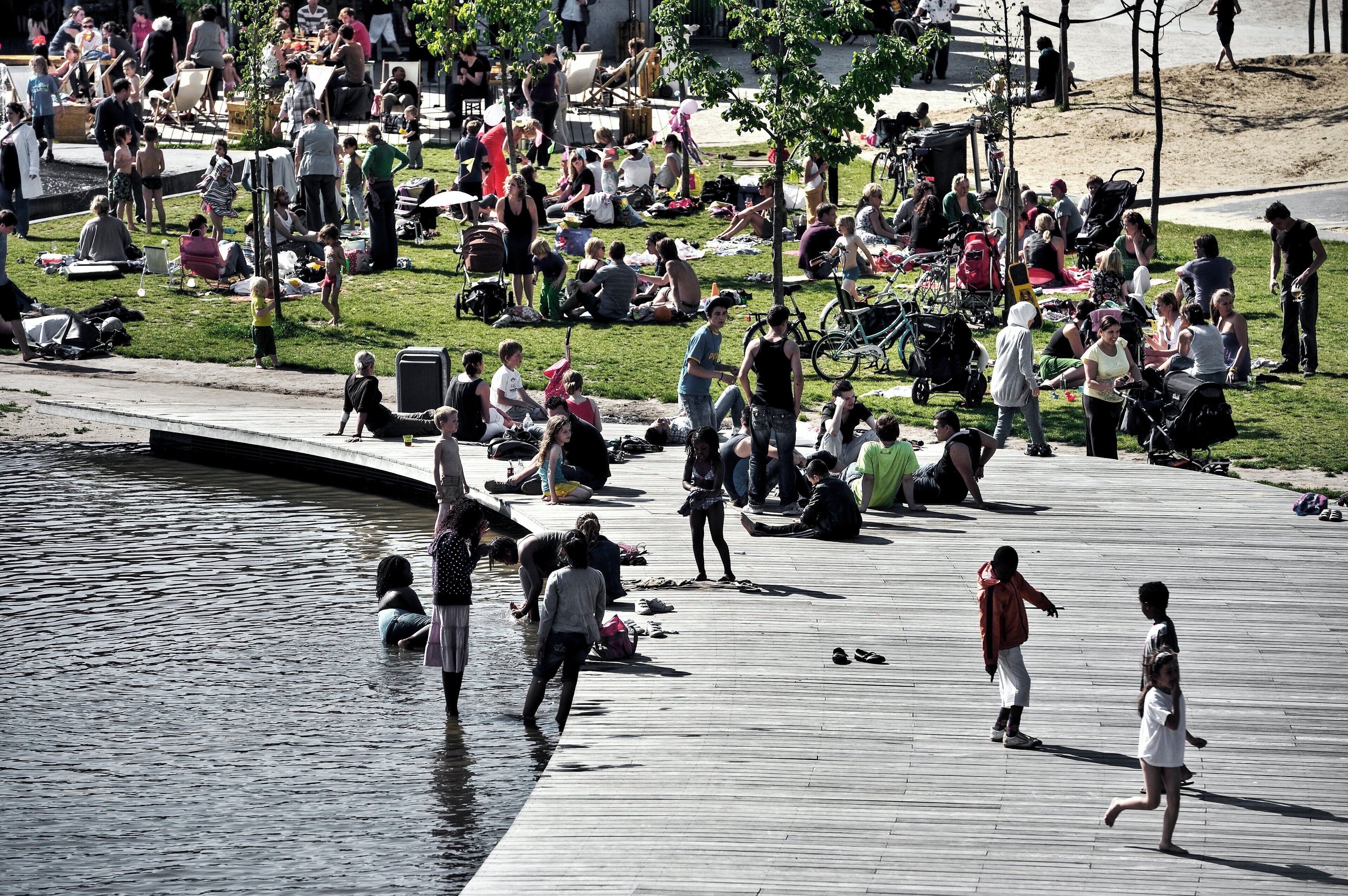 A public square with a water feature and people engaging in various activities.