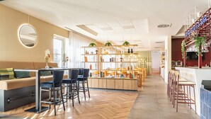 Un intérieur moderne comprenant un bar, des espaces pour s’asseoir et une cuisine.