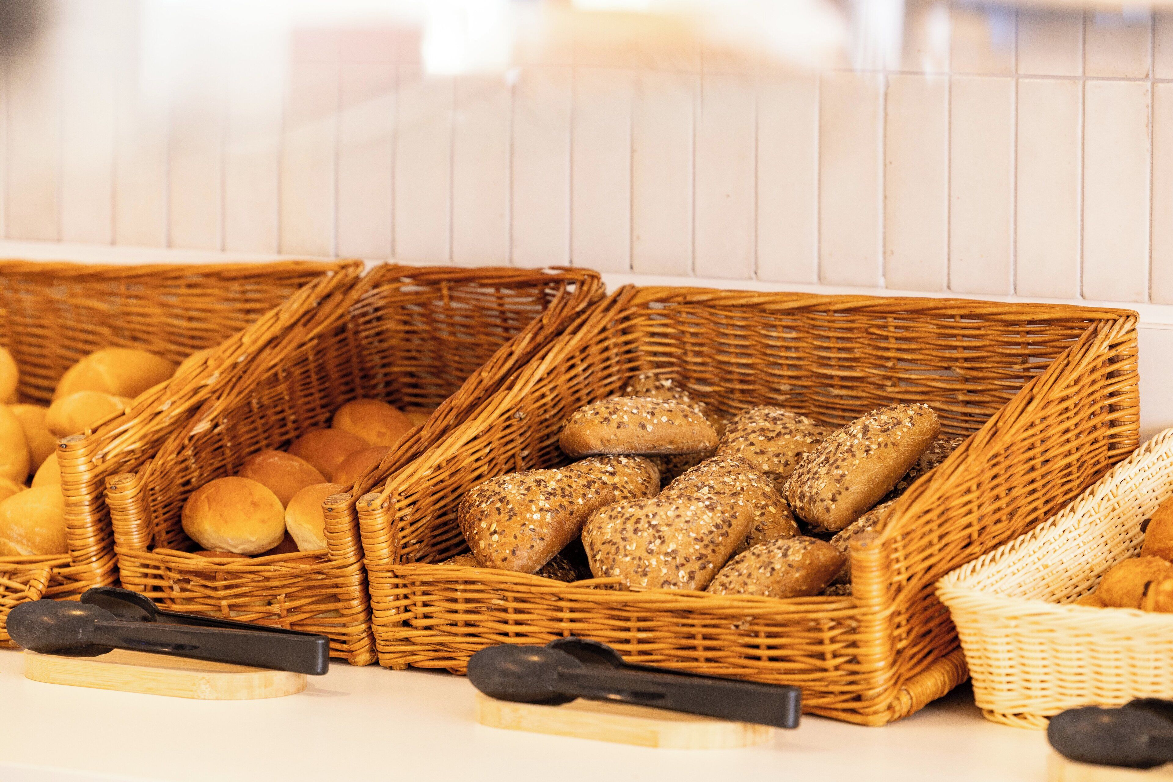 Wicker baskets filled with various types of bread and rolls.