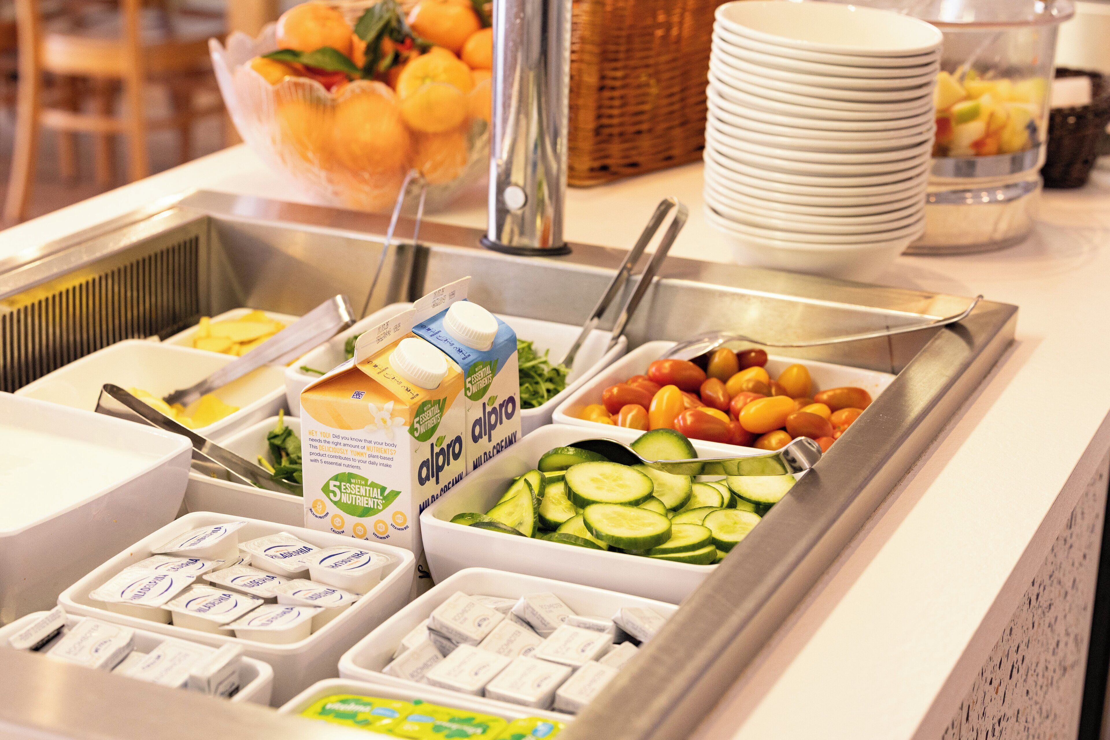 A buffet with various food items including fruits, vegetables, and dairy products.