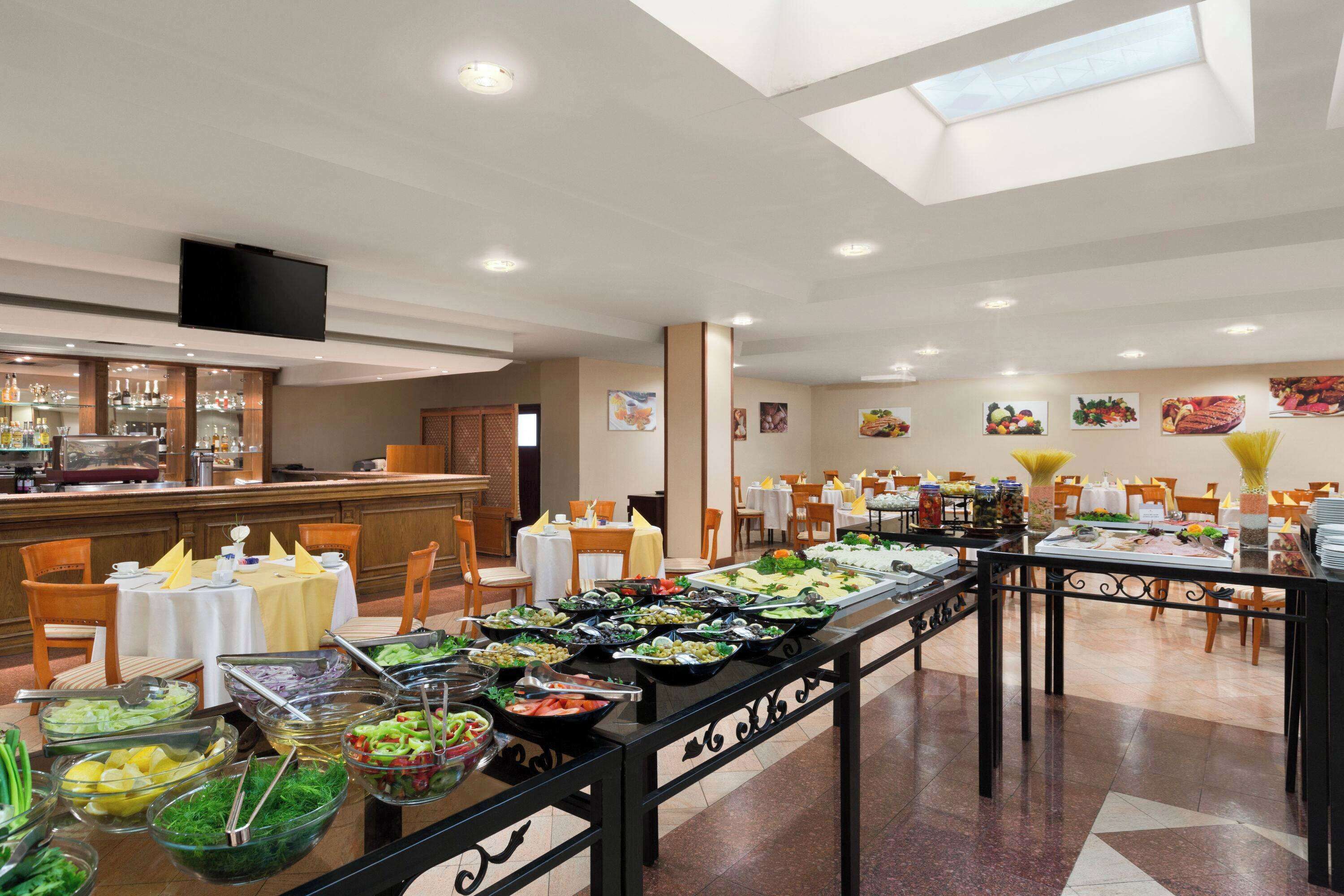 A buffet area with various food stations, tables, and chairs arranged for dining.