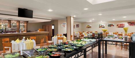 A buffet area with various food stations, tables, and chairs arranged for dining.