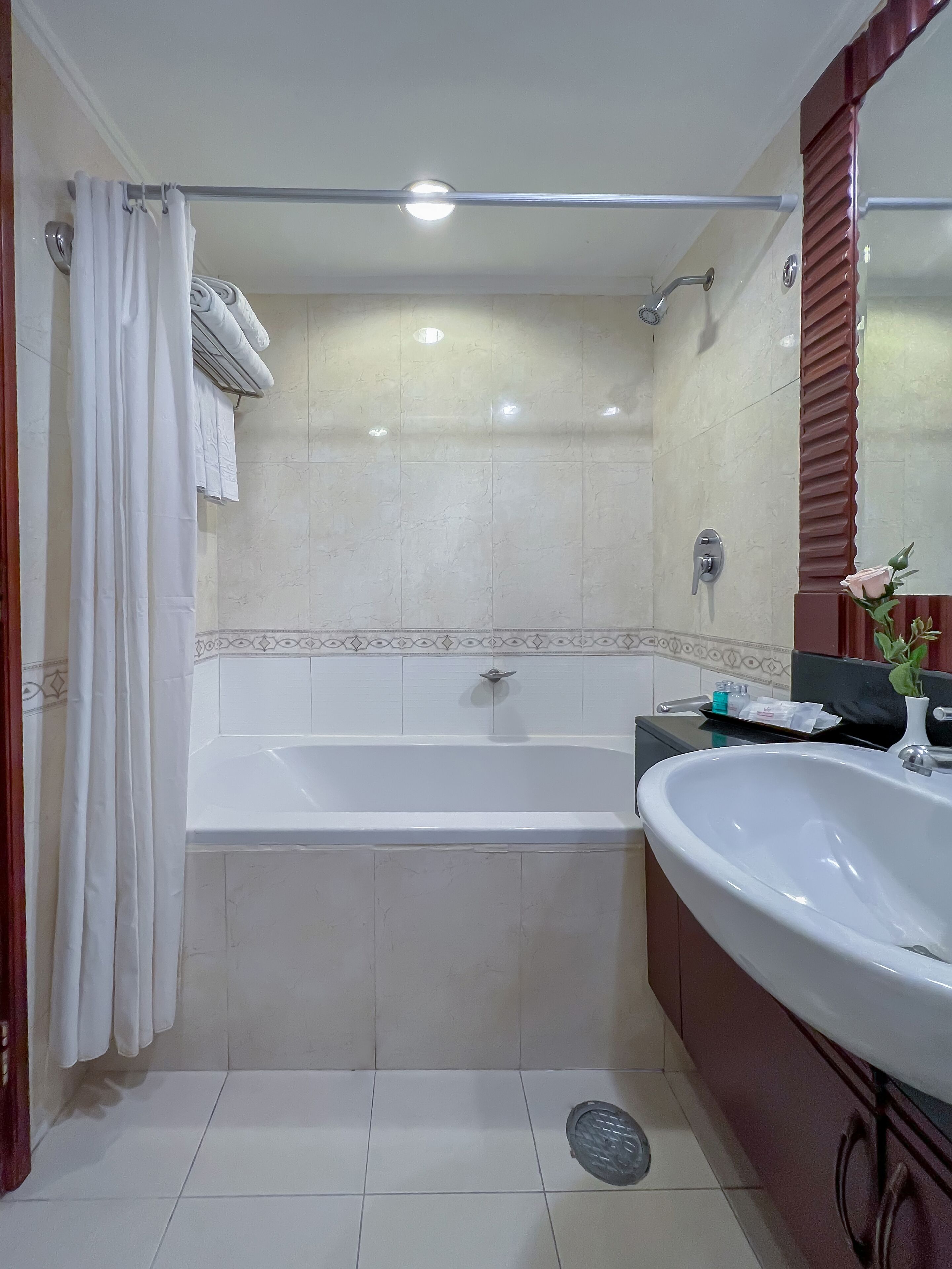 A bathroom with a bathtub, a sink, and a shower area.