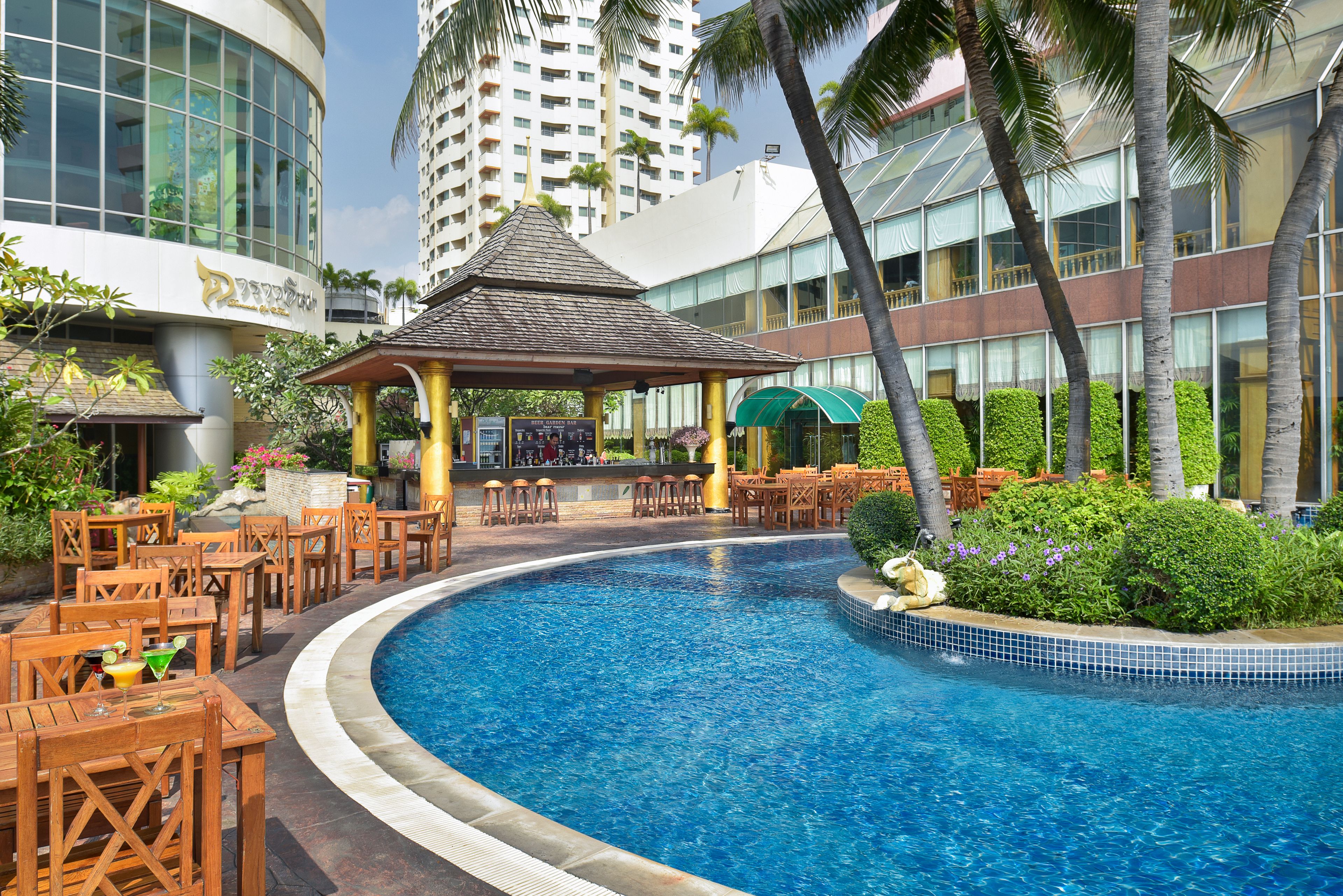 A pool area with a gazebo, outdoor seating, and a view of surrounding buildings.