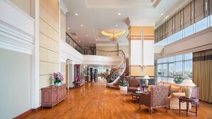 A spacious lobby with a grand staircase, wooden flooring, and large windows offering a city view. - Prince Palace Hotel Bangkok (Bangkok)