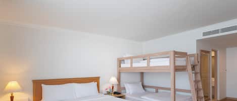 Ein Zimmer mit einem großen Bett, einem kleineren Bett, einem Nachttisch mit einer Lampe und einer Holzleiter.
