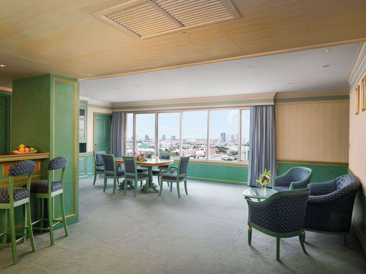 Una habitación con comedor, bar y ventanas amplias con vista a la ciudad.