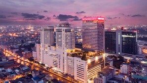 A cityscape with modern high-rise buildings, a river, and a sunset sky. - Prince Palace Hotel Bangkok (Bangkok)