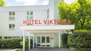 Een moderne hotelentree, met de naam 'HOTEL VIKTORIA' duidelijk zichtbaar.