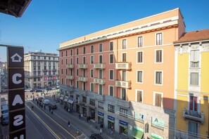 A multi-story building with balconies, storefronts, and a clear sky. - Casual Eclettico Milano Hotel by Casual Hoteles (Milan)