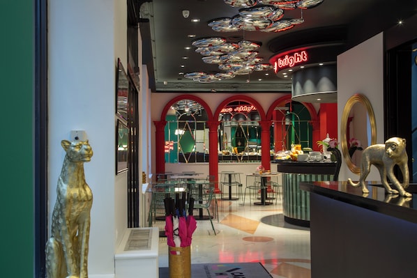 Ein Restaurant mit modernem Interieur, das eine Theke mit Spiegel und eine dekorative Tierstatue zeigt.