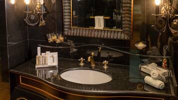 A bathroom with a large mirror, a sink, and wall sconces.