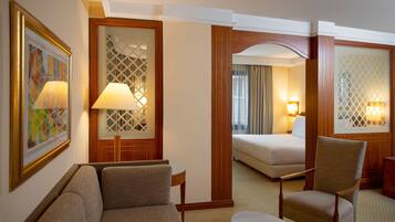 A hotel room with a sofa, armchair, and a bed.