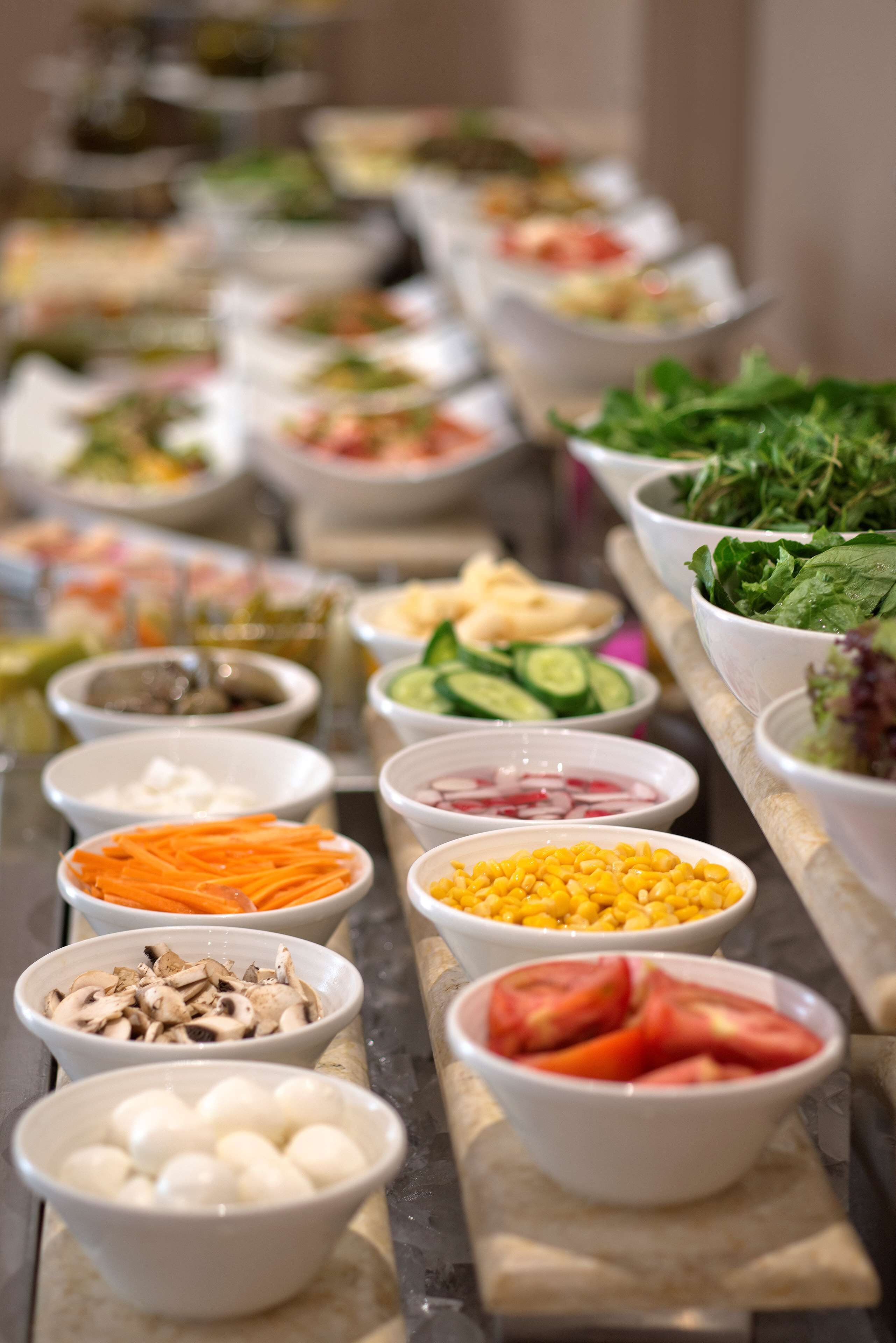 Un buffet proposant une variété d’aliments, notamment des légumes, des fruits et des fromages.