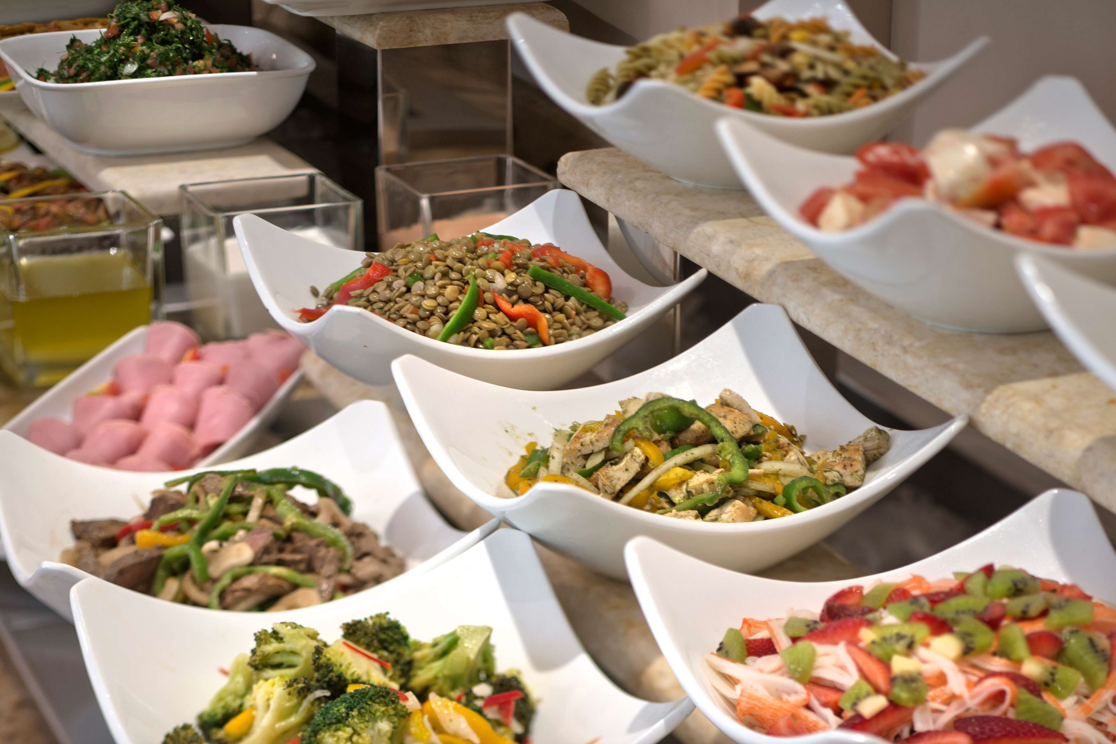 A buffet with various dishes including salads, meats, and vegetables.