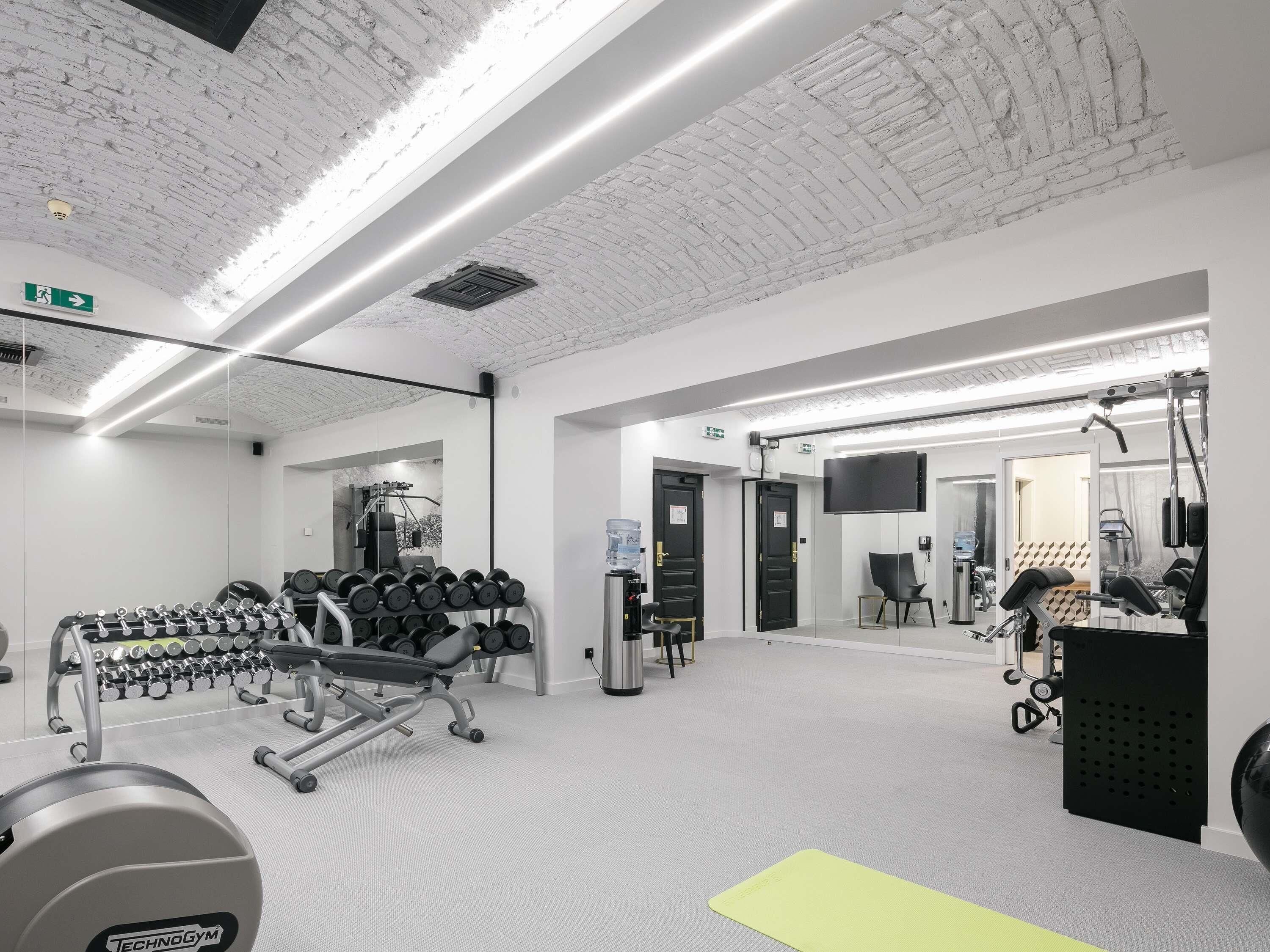 A gym with exercise equipment, a water dispenser, and a mirror.