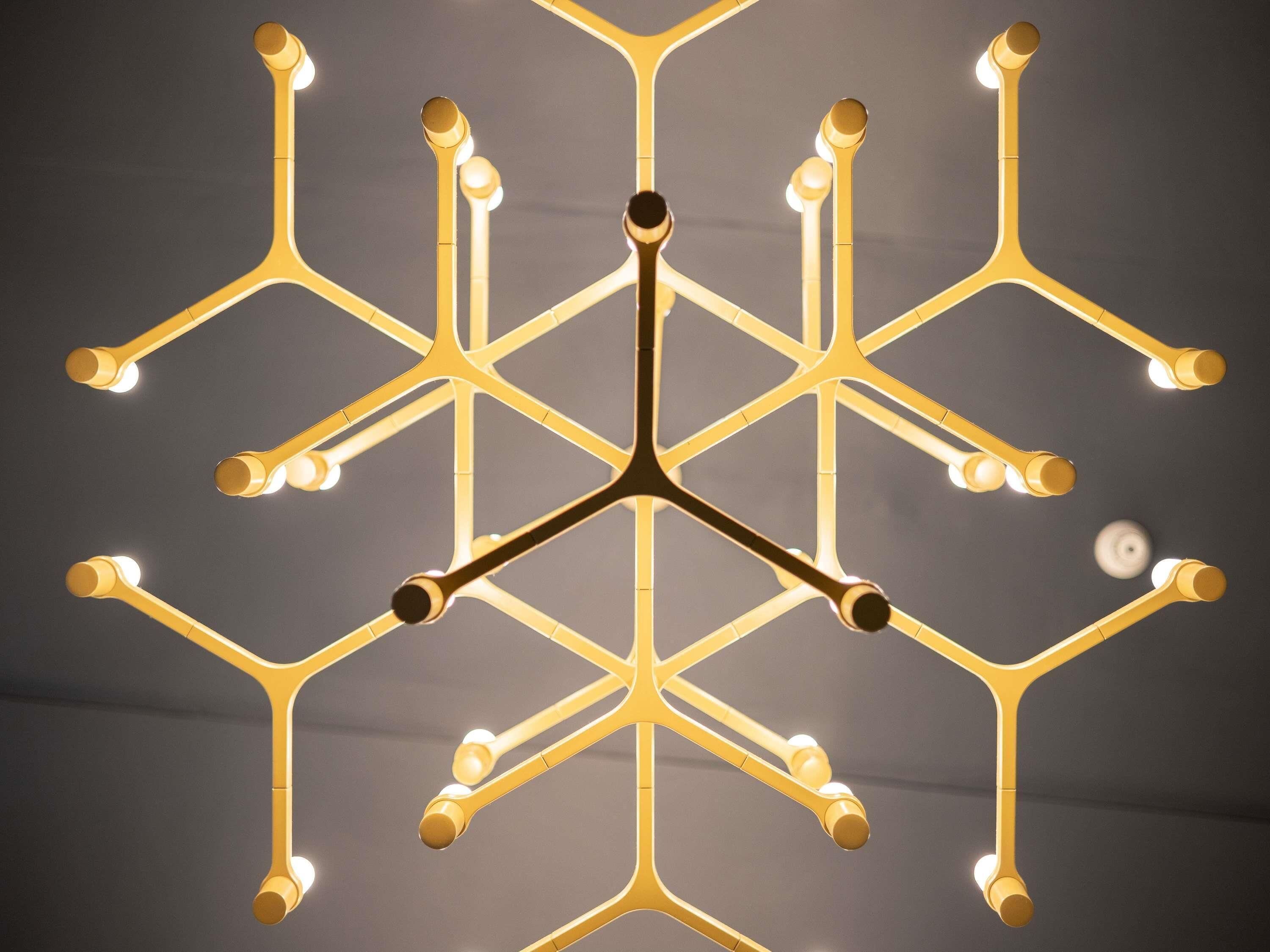 En geometrisk kristallkrona med flera armar och ljuskällor.