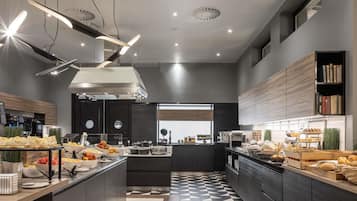 A modern kitchen with a central island, built-in appliances, and a variety of food items displayed.
