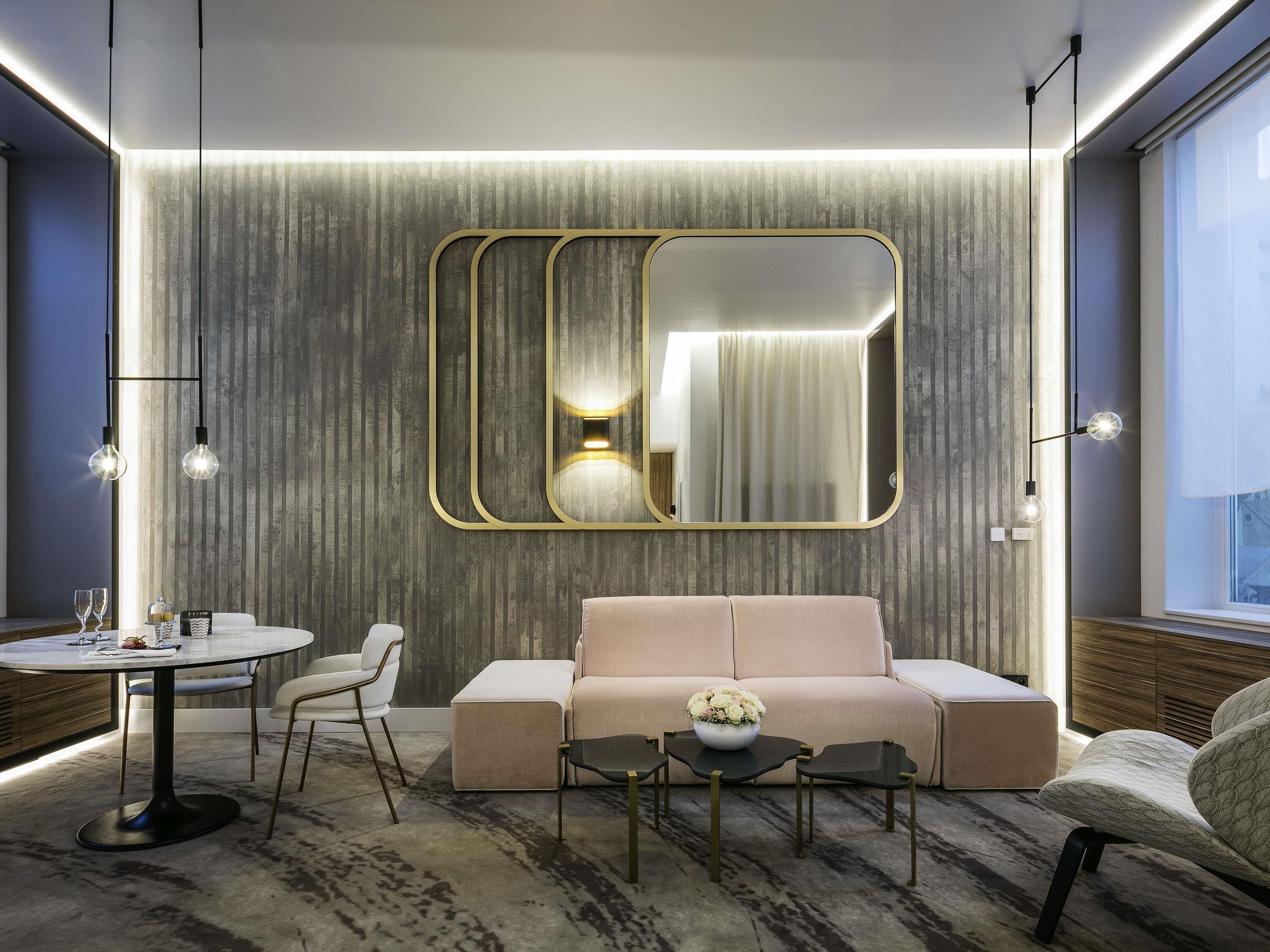 A modern living room with a round dining table, a sofa, and a coffee table.