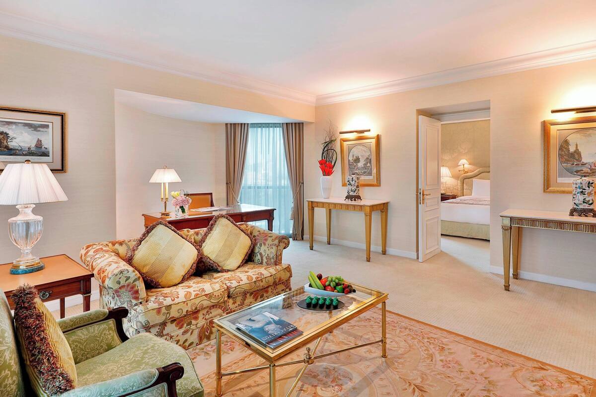 A well-furnished living room with a sofa, armchair, coffee table, and a dining area with a table and chairs.