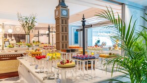 A buffet with various desserts and a clock tower model.