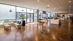 A spacious, modern office with large windows, wooden flooring, and contemporary furniture. - Scandic Sydhavnen (Copenhagen)